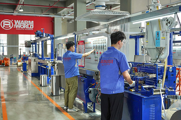 工人在操作電伴熱帶護套擠出設備。 環瑞電熱供圖